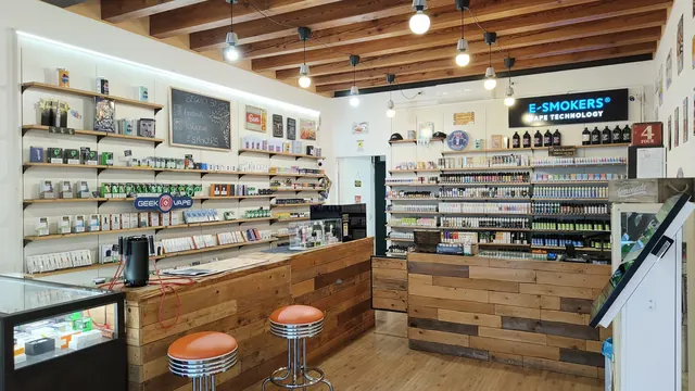 Vista interna ampia del negozio E-smokers Mirano con banconi in legno e pareti espositive - negozio sigarette elettroniche Mirano